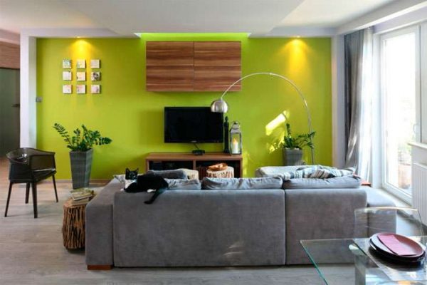 телевизор в интерьере гостиной на зелёной стене