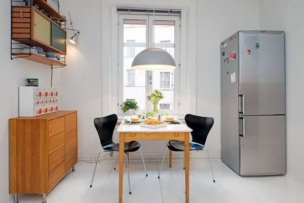 металлический холодильник на маленькой кухне у окна