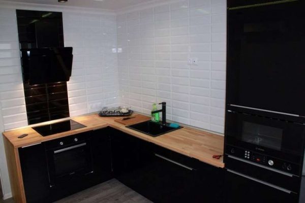 чёрная кухня без верхних шкафов с деревянной столешницей