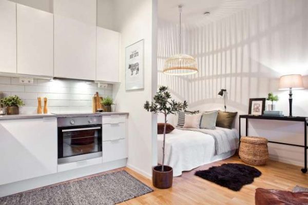 белый интерьер кухни со спальной зоной в однокомнатной квартире